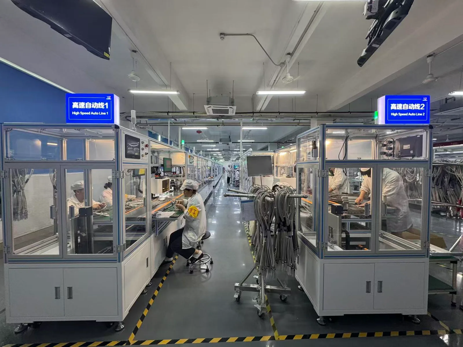 Two high-speed automated assembly lines running on the Infraeo production floor, with operators at each